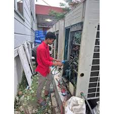 Technician inspecting a tall outdoor HVAC unit